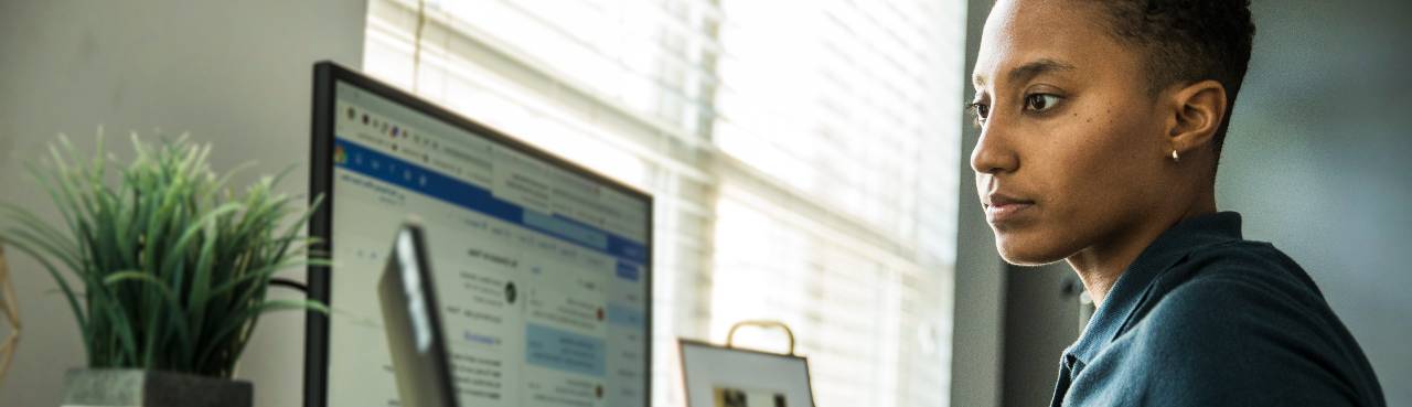 Vrouw kijkt op laptop en scherm