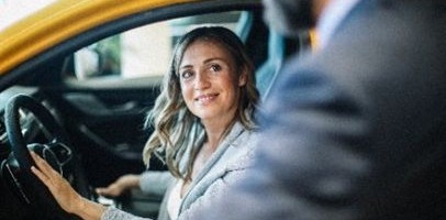 Een vrouw zit achter het stuur in een auto