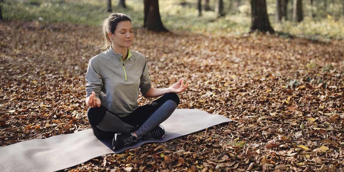 vrouw in bos op yogamat