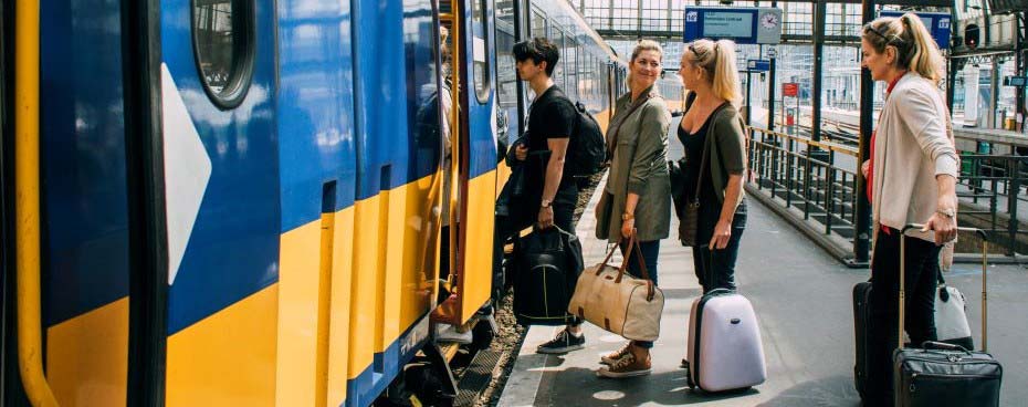 Een afbeelding van mensen die op een perron staan en klaar zijn om in een trein te stappen